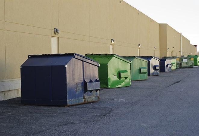 a construction worker moves construction materials near a dumpster in Hendersonville